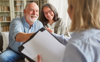 Happy couple sitting with an equity release adviser discussing the Equity Release Council