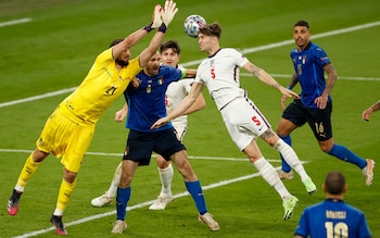 Italy's goalkeeper Gianluigi Donnarumma and England's John Stones compete for the ball during the Euro 2020 soccer championship final between England and Italy at Wembley stadium in London, Sunday, July 11, 2021