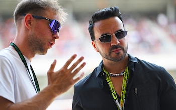 Singer Luis Fonsi being given a tour in the Red Bull garage