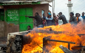 Supporters of Kenya's opposition party, National Super Alliance, take shelter behind a building as they demonstrate in Kibera slum, in Nairobi, after Kenya's Supreme Court dismissed two petitions to overturn the country's October 26 presidential election re-run 