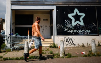 Man walking past abandoned SuperDrug