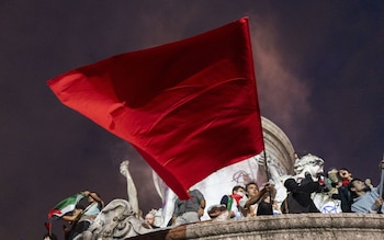 People fly a red flag of the far-left during celebrations of the election results following voting in the second round of legislative elections in Paris, France, on Sunday, July 7, 2024