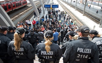 A group of refugees headed for Sweden wait after being stopped by police at the central station in Luebeck, Germany