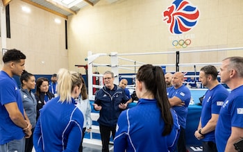 Britain's Prime Minister Keir Starmer (C) talks with Team GB athletes during his visit at the Performance Lodge