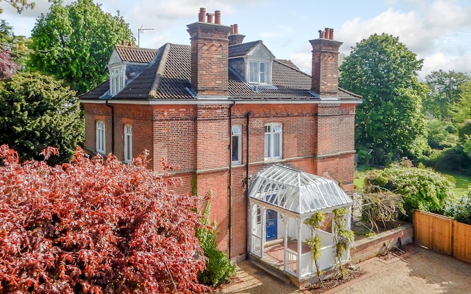 A red-brick house with a glass porch