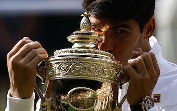 Carlos Alcaraz kisses the Wimbledon trophy