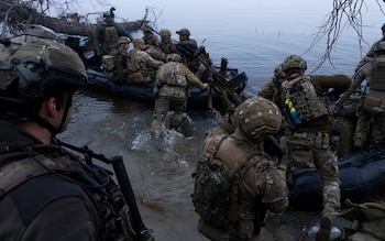 Ukrainian servicemen board a boat on the shore of Dnipro river at the frontline near Kherson
