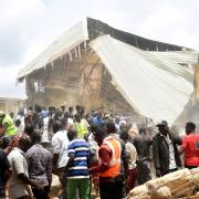 People and rescuers gather at the scene of a collapsed two-storey building in Jos, Nigeria (AP)