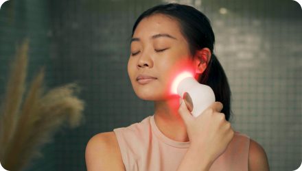 Woman using TheraFace on cheek