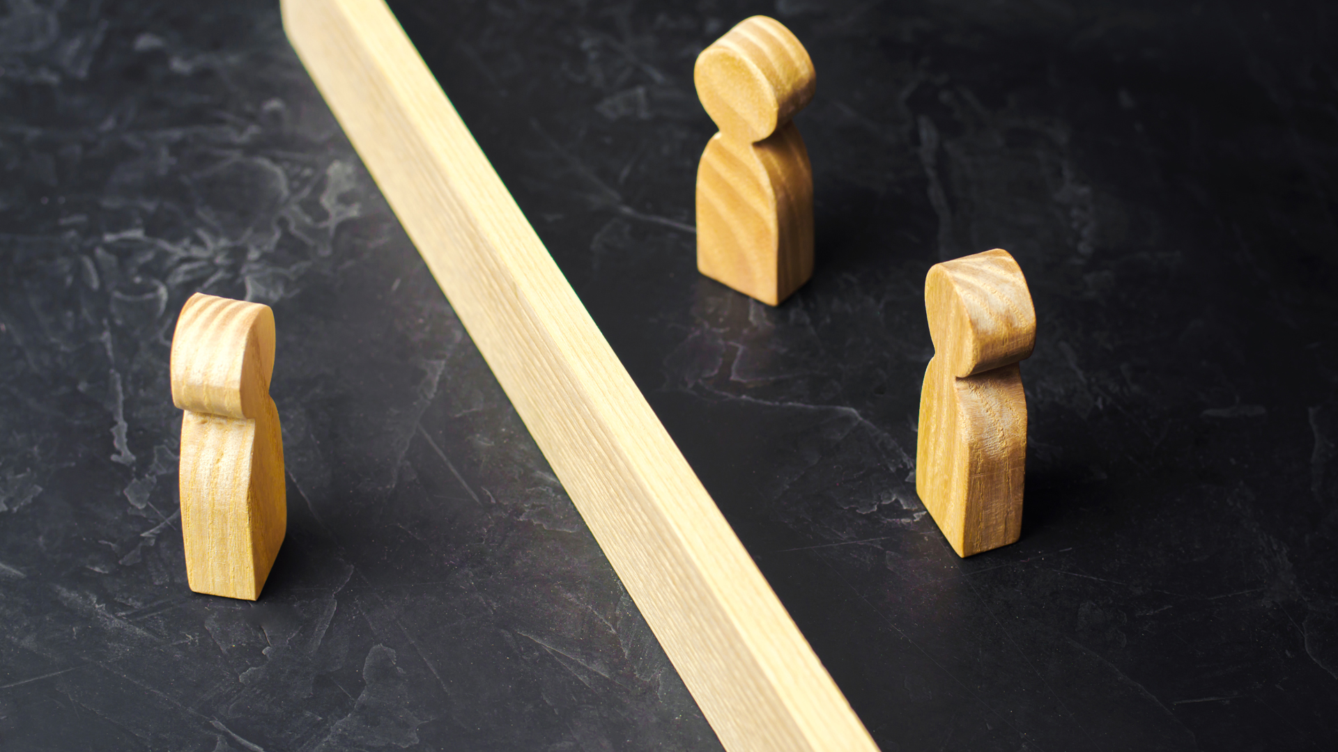 Three wooden  people blocks with a wooden line in the middle