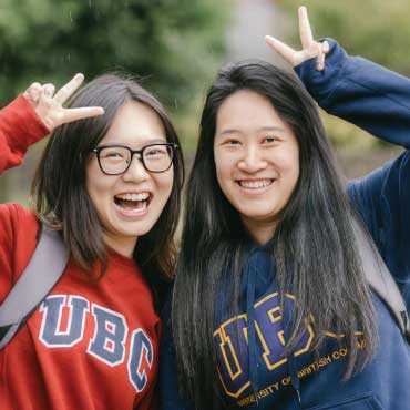 Two happy students wearing UBC sweatshirts