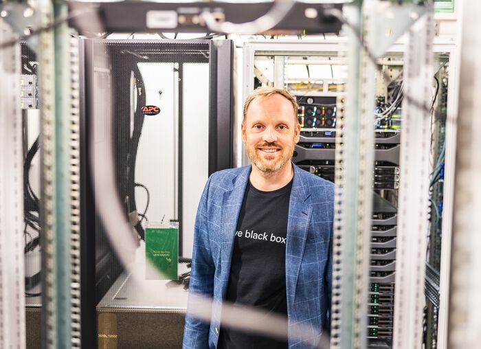 Professor Ole-Christoffer Granmo står mellom superdatamaskiner