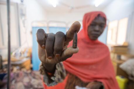 Samah holds the bullet that was removed from her 8-year-old daughter Fatima's head at UNICEF-supported Aljekaika hospital in northern Sudan..