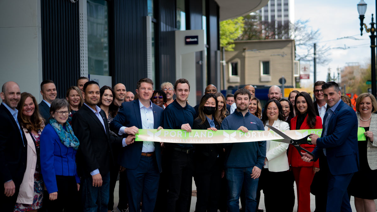 Large group of people crowded around a ribbon-cutting ceremony.