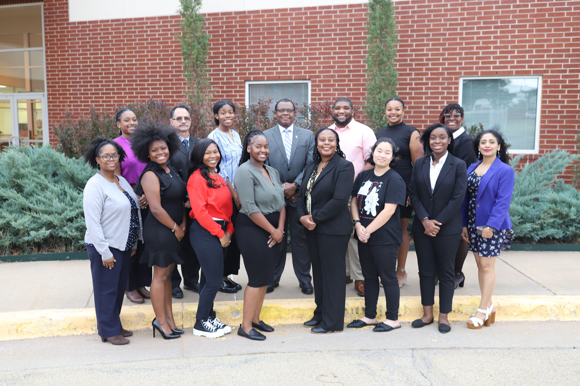 A group of Black students and their instructors stand outdoors