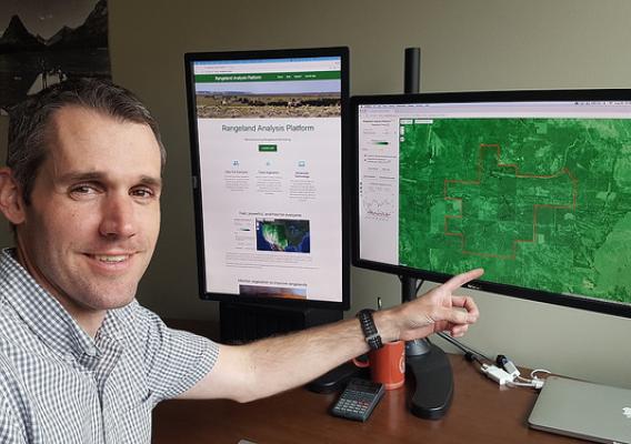 Brady Allred pointing to a computer monitor