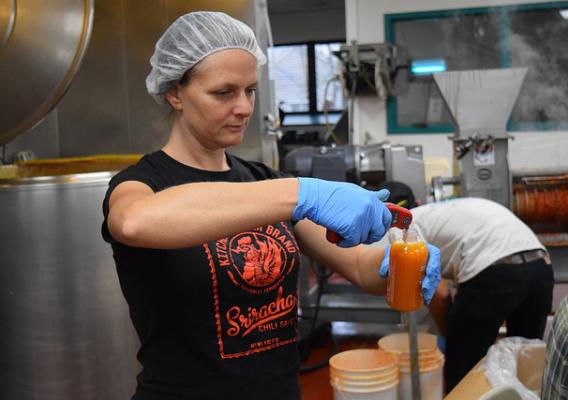 Caroline Pam, co-owner of Kitchen Garden Farm, checking the temperature of a bottle of her award winning sriracha