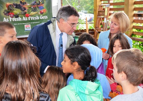 U. S. Representative Rush Holt (left) and USDA Food and Nutrition Service Mid-Atlantic Regional Administrator Pat Dombroski mingle with proud children showing off their school garden before tasting an eatable flower grown just a few feet away.