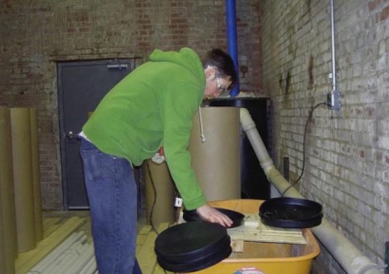 Here a student in the program places sections of wood in rearing tubes so the insects that emerge can be identified. (Photo: William Harris)