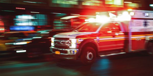 Photo of an ambulance with lights and siren on.