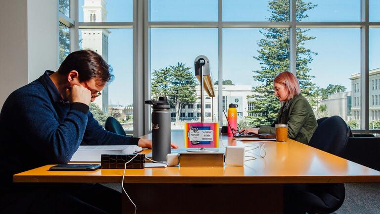 Students study at a table in the library.