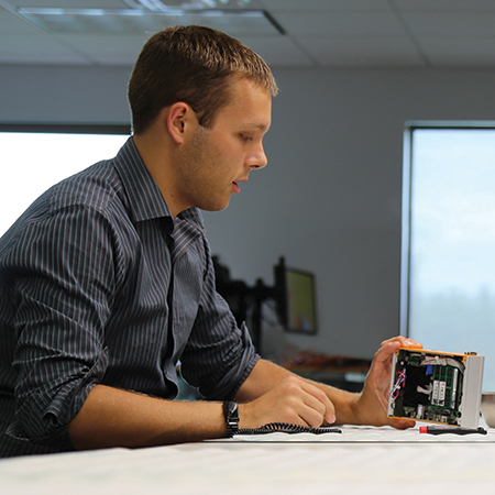 Young man working on a technology device in the office.