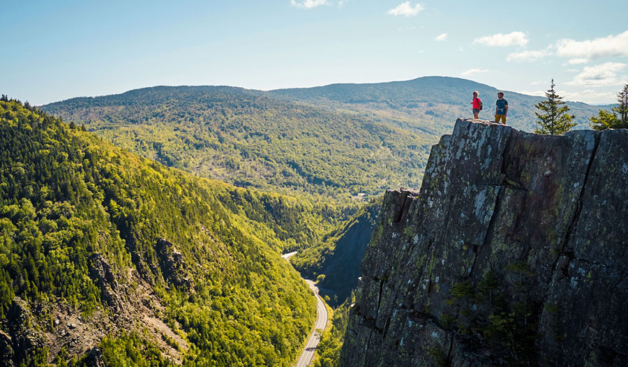 two hikers on a mountain cliff