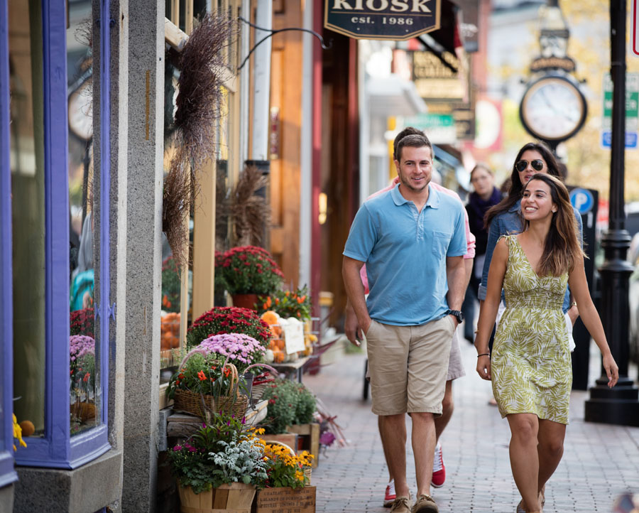 a man and woman walking next to shops