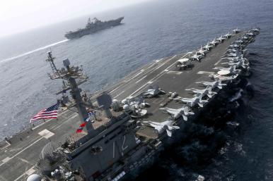 The US Navy carrier Abraham Lincoln sails alongside an escort destroyer - source: U.S. Navy