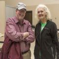 A man and a woman stand together in a meeting space.