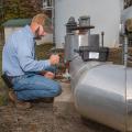 A man adjusts a valve on a water pipe.