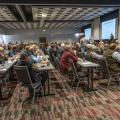 A large room full of people watching a presentation.