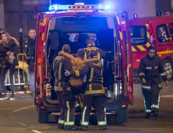 Equipes de resgate socorrem torcedores do lado de fora do Stade de France após as explosões (Foto: EFE/EPA/IAN LANGSDON)