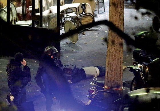 Polícia em Paris ao lado de corpos nas ruas. (Foto: Christian Hartmann/Reuters)