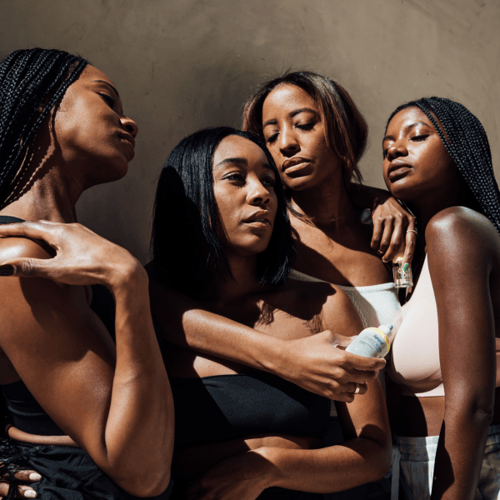 4 black content creators wearing black and white clothing posing together in the sun