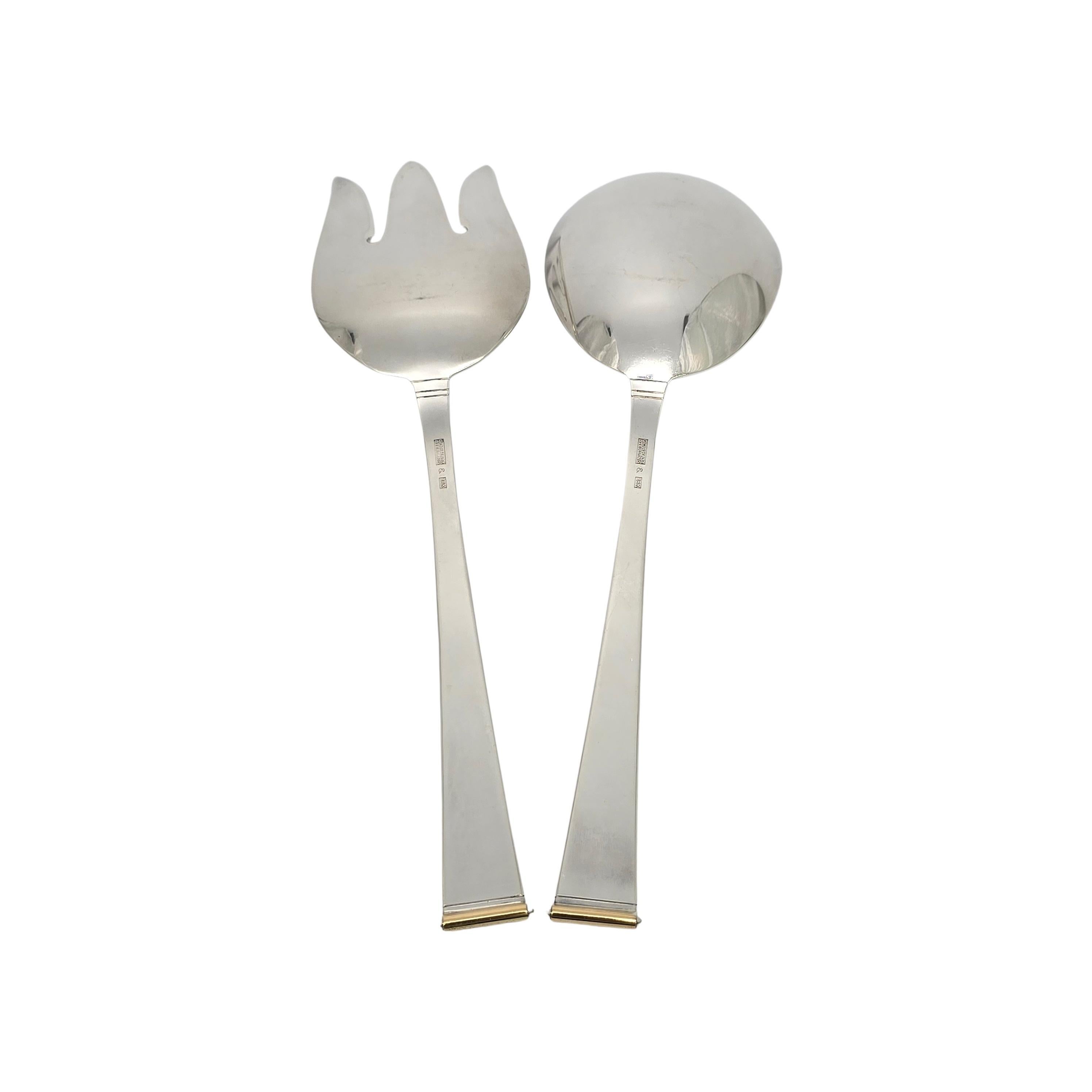 Sterling silver salad serving spoon and fork set from the Gold Tip pattern by Gorham.

No monogram

These large serving utensils are a simple and classic design featuring an 18K gold detail at the top of each handle.

Spoon measures approx 9 1/16