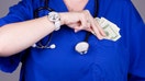 A doctor or a nurse placing money in her pocket.