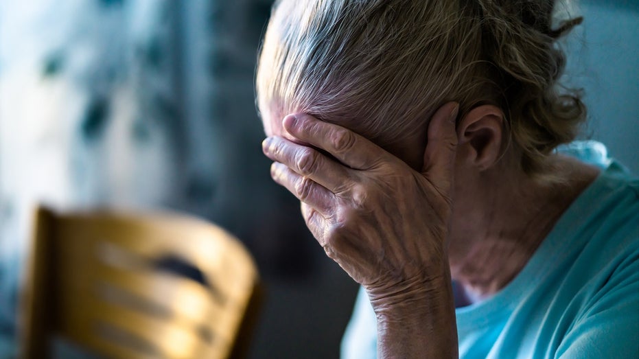 elderly woman head in hand