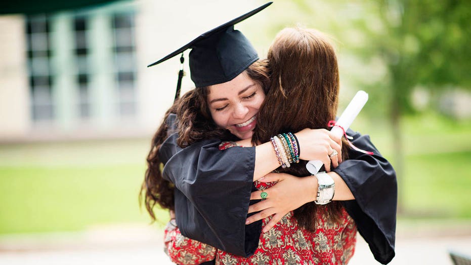 graduate hugging parent