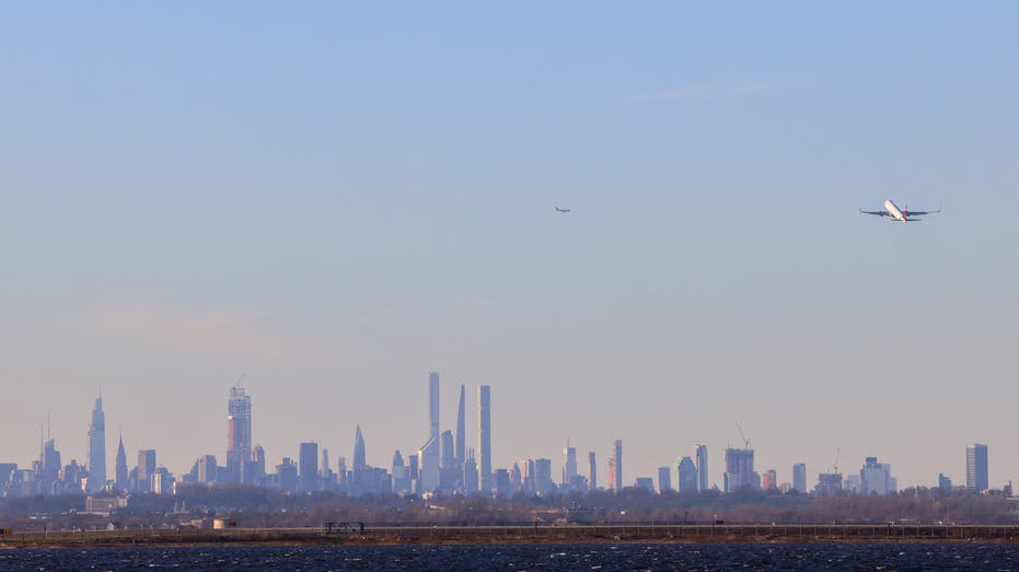 Plane takes off from JFK with NYC skyline in background