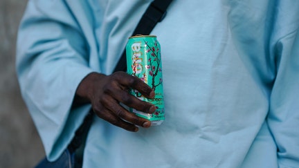 PARIS, FRANCE - FEBRUARY 28: Cali Chiki wears glasses a pale blue oversized pullover from Asos, drinks an Arizona iced tea beverage in a metallic can, on February 28, 2021 in Paris, France. (Photo by Edward Berthelot/Getty Images)
