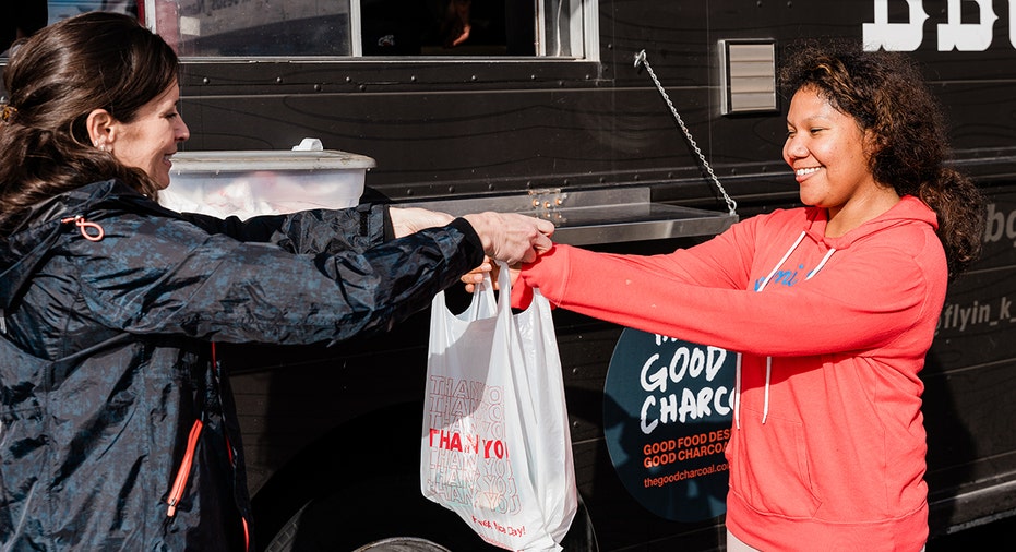 a volunteer hands a meal over to a customer