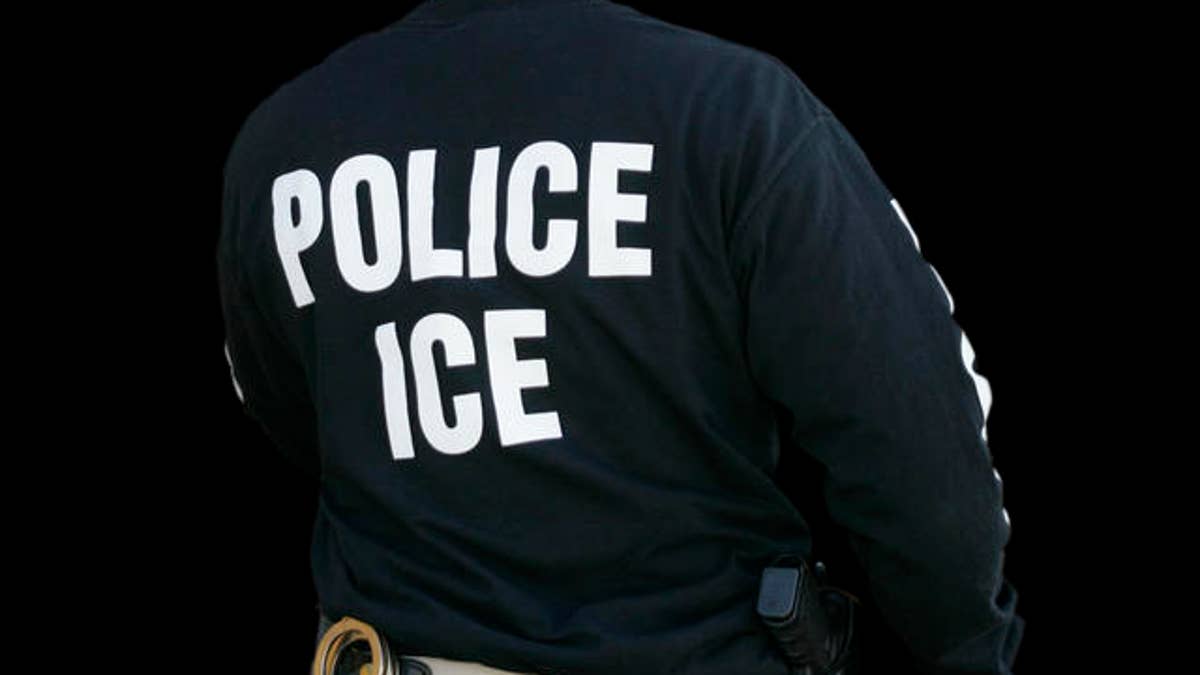 An Immigration and Customs Enforcement agent enters a restaurant to remove evidence in Cheektowaga, N.Y., Wednesday April 16, 2008. A Buffalo-area restaurant owner and nine business associates are accused of smuggling illegal Mexican immigrants into the U.S. to work in restaurants in New York, Pennsylvania, Ohio and West Virginia. (AP Photo/David Duprey)