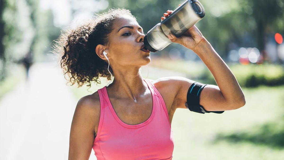 Woman drinks from water bottle