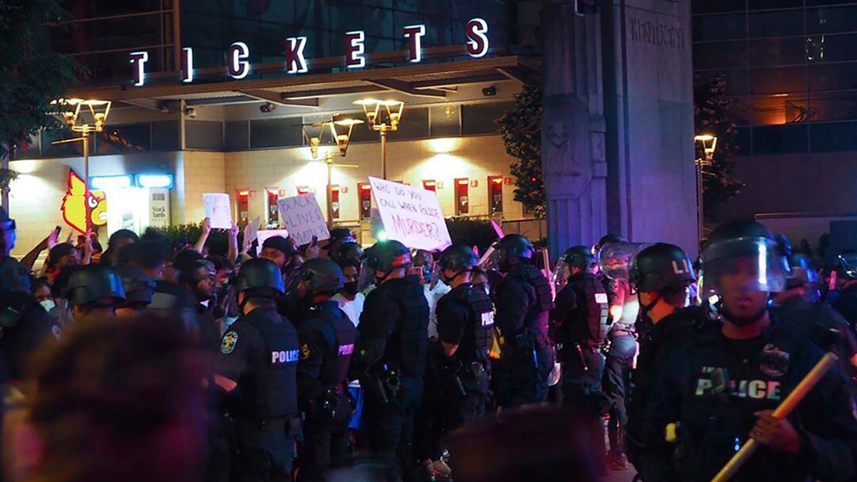 In this photo provided by instagram account of @mckinley_moore, police officers gather Thursday, May 28, 2020, in downtown Louisville, Ky., as protesters demonstrate against the killing of Breonna Taylor, a black woman fatally shot by police in her home in March. (@mckinley_moore via AP)