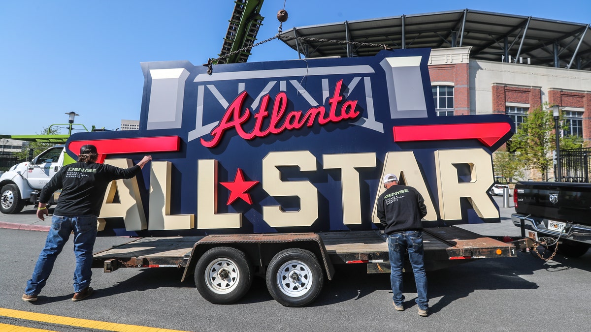 Workers load an All-Star sign onto a trailer after it was removed from Truist Park in Atlanta, Tuesday, April 6, 2021. (John Spink/Atlanta Journal-Constitution via AP)