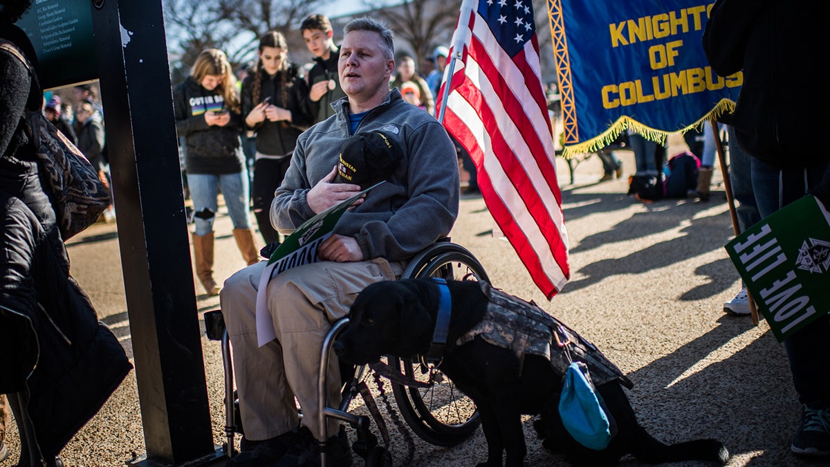 Iraq and Afghanistan veteran Kirby Bowling of Maryland and his dog, Sig, are shown during the national anthem at the annual March for Life on Jan. 19, 2018, in Washington, D.C. (Salwan Georges / Washington Post via Getty Images)