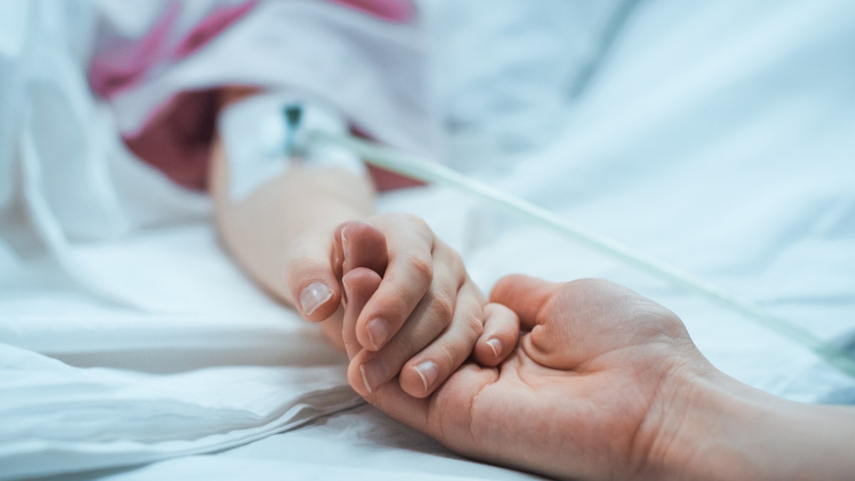 hospital setting patient holds hand