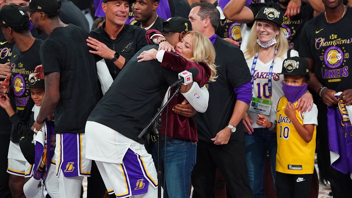 LeBron James, #23, hugs Jeanie Buss of the Los Angeles Lakers, celebrating on court after winning Game Six of the NBA Finals against the Miami Heat on October 11, 2020, at AdventHealth Arena, in Orlando, Florida.