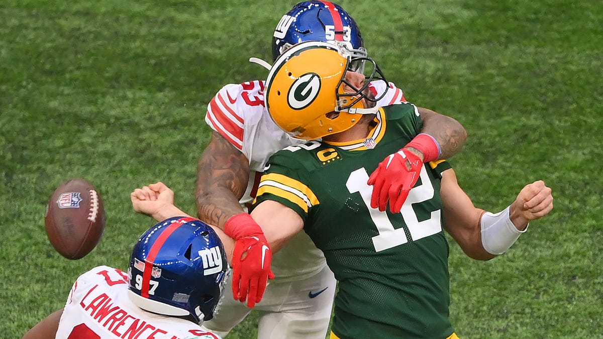 Aaron Rodgers of the Green Bay Packers is sacked by Oshane Ximines of the New York Giants and fumbles the ball during the fourth quarter at Tottenham Hotspur Stadium on Oct. 9, 2022, in London.